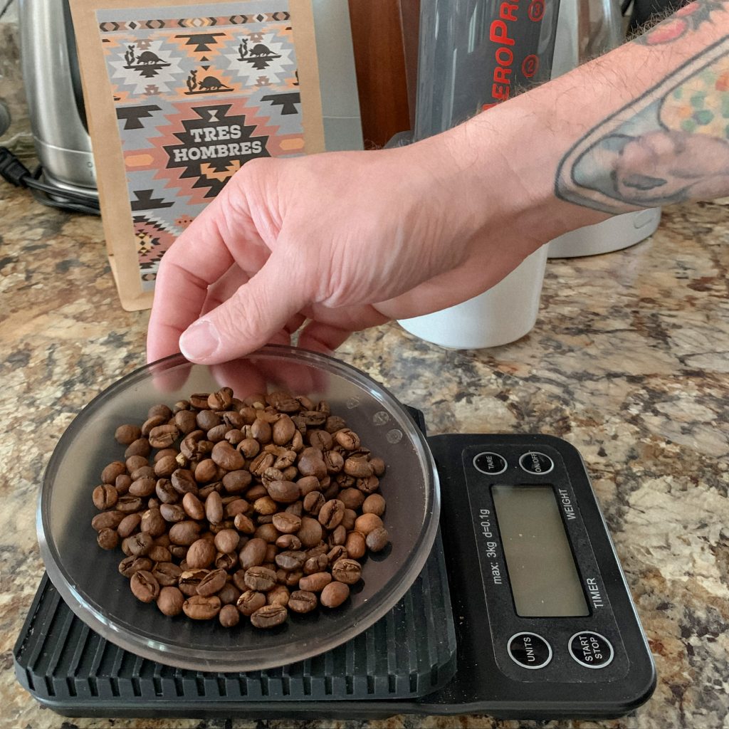 weighing whole beans to grind for the Chemex Brewing Method using a coffeesock reusable filter