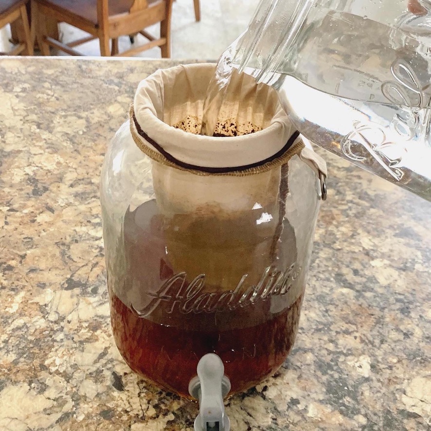 Cold brew coffee, being made in a gallons size mason jar, with Haciendo Coffee Roasters beans